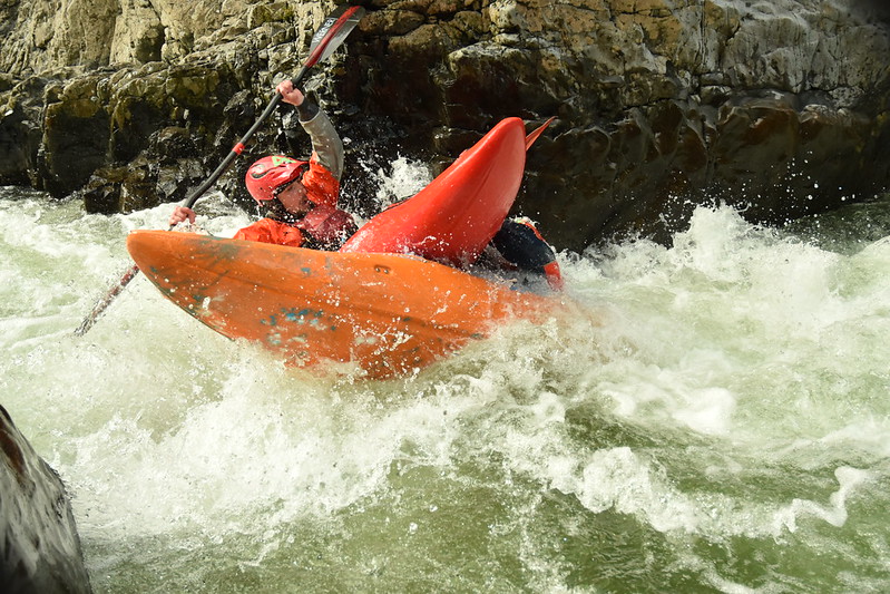 One whitewater kayaker crashing into another kayaker